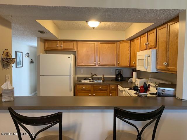 7175 South A1a Street, Unit B212 St. Augustine, FL 32080 - Photo 6 of 29 a kitchen with a refrigerator a stove a sink and a dining table