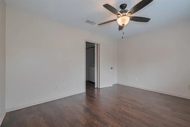 an empty room with a fan and a ceiling fan