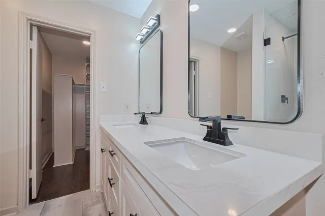 a bathroom with double vanity sinks and a mirror