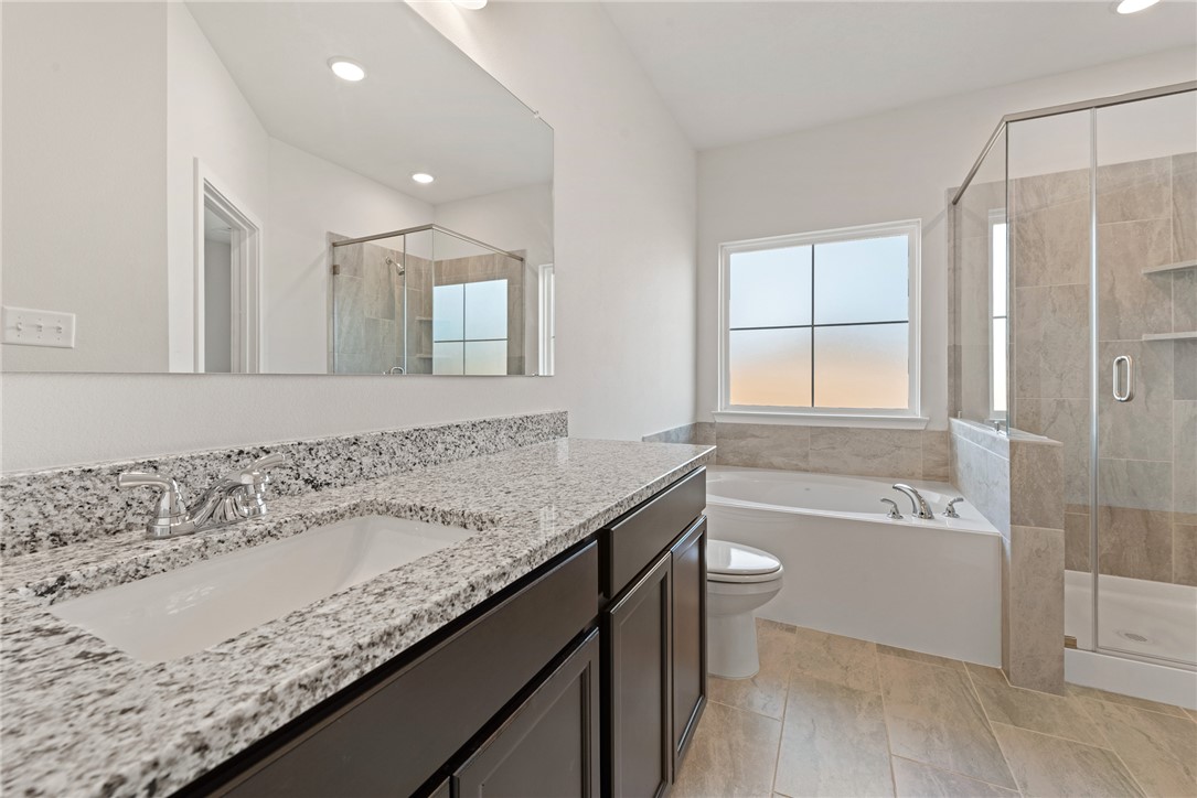 2412 Rooke Road Bryan, TX 77807 - Photo 25 of 35 a bathroom with a granite countertop sink a toilet and bathtub
