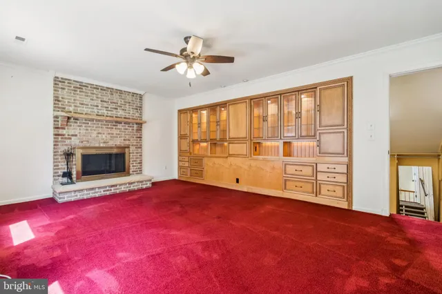 an empty room with windows and fireplace