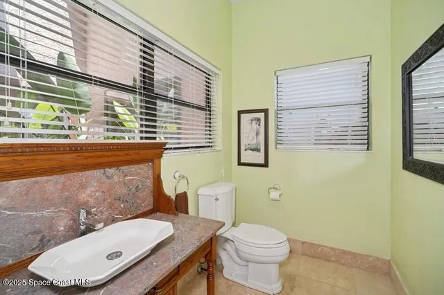 a bathroom with a toilet a sink and mirror