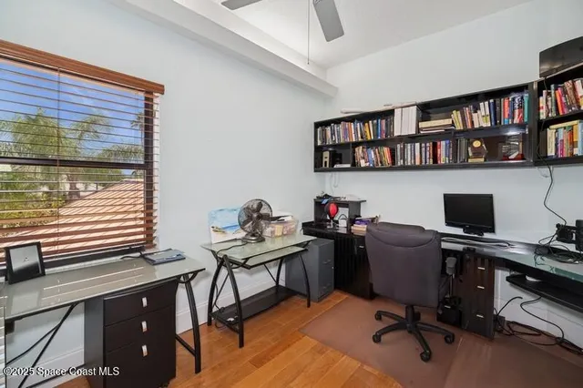a view of a workspace with furniture and a book shelf
