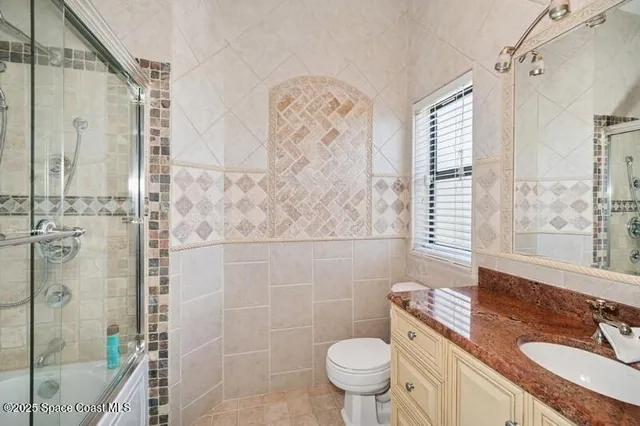 a bathroom with a granite countertop sink toilet mirror and shower