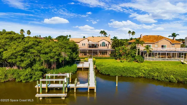 an aerial view of a house with swimming pool patio and lake view