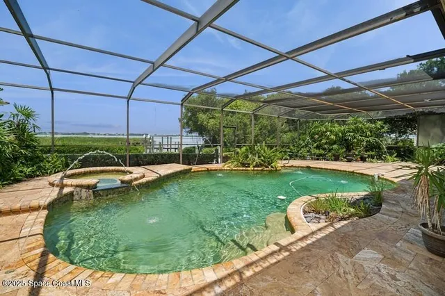a view of a swimming pool with a patio and a yard