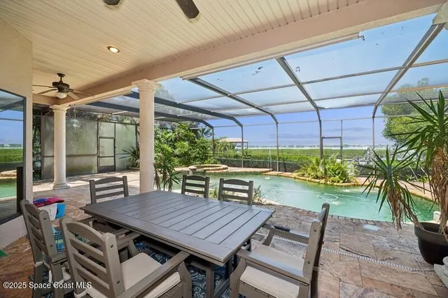 a view of a patio with table and chairs potted plants and palm trees