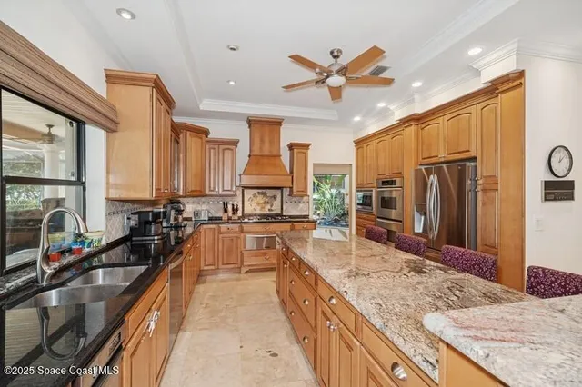 a large kitchen with kitchen island granite countertop a large counter top appliances a sink and living room view