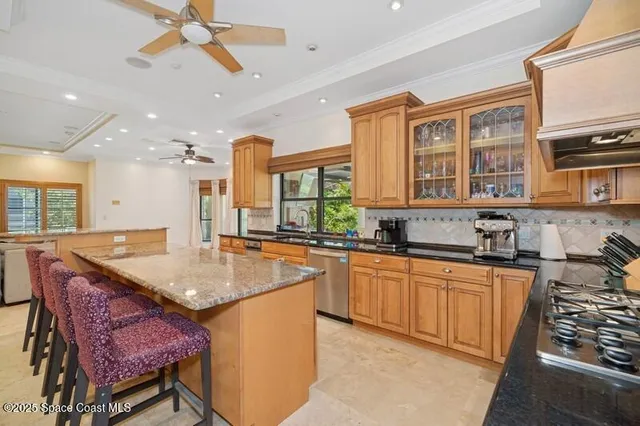a kitchen with stainless steel appliances granite countertop a sink a stove and a refrigerator