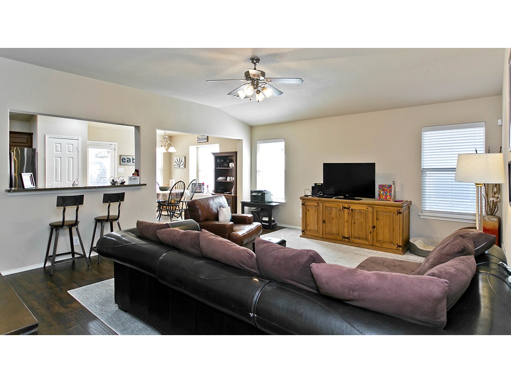 1808 Sand Creek Road Cedar Park, TX 78613 - Photo 12 of 25 Living area featuring vaulted ceilings, a ceiling fan with integrated lighting, and two windows with blinds