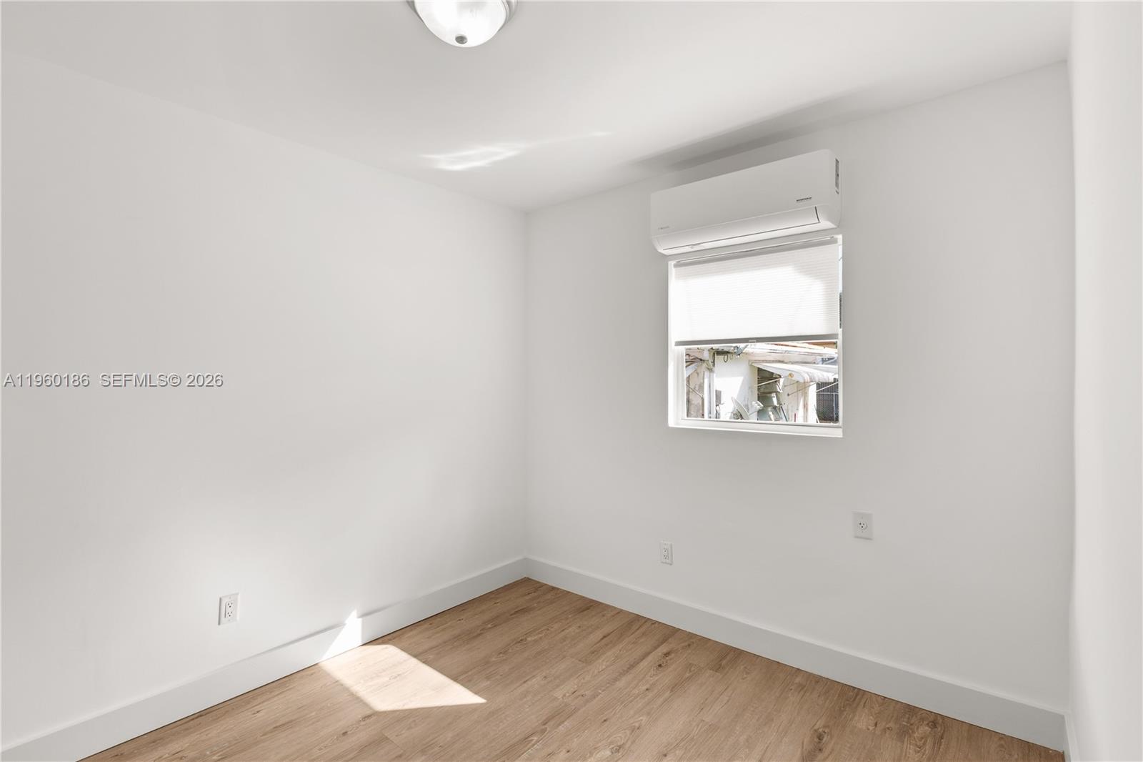 2508 Southwest 10th Street, Unit 2508 Miami, FL 33135 - Photo 17 of 26 an empty room with wooden floor and windows