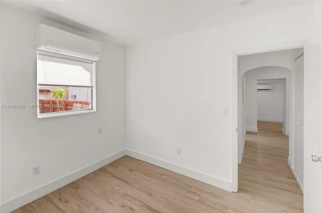 an empty room with wooden floor and a window