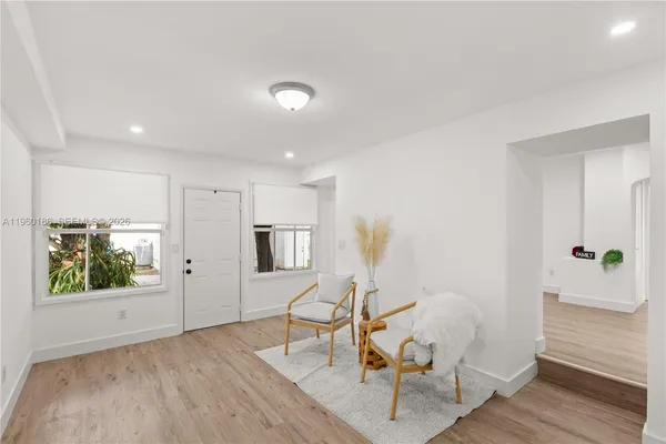 a view of a room with wooden floor lounge chair and windows