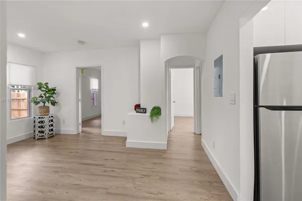 a view of a hallway with wooden floor and a dining room