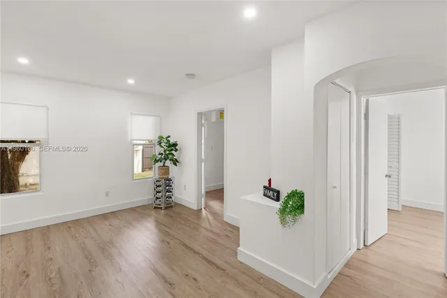 a room with wooden floor and a potted plant