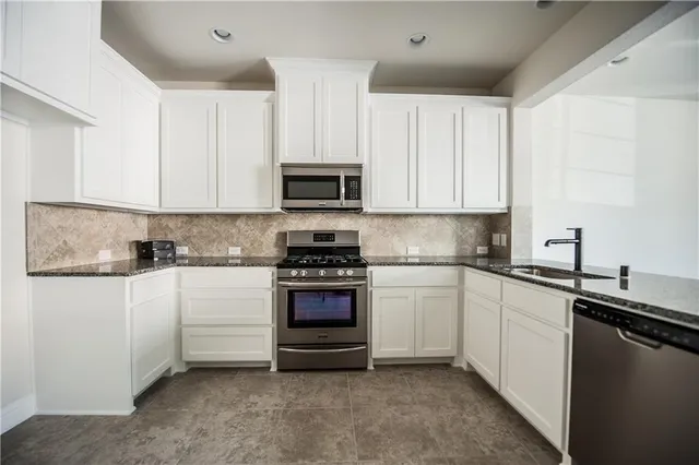a kitchen with stainless steel appliances granite countertop a sink and cabinets