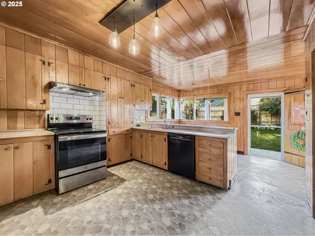a kitchen with stainless steel appliances kitchen island granite countertop a stove and a sink