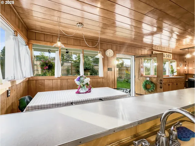 a view of a kitchen with a sink and large windows