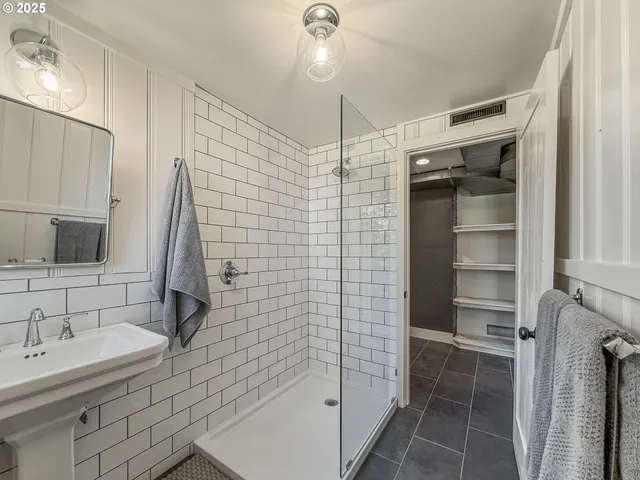 a bathroom with a sink shower and a mirror