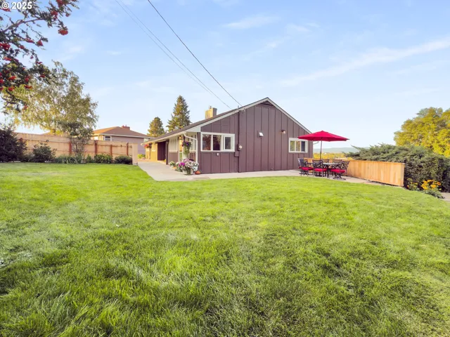 a front view of house with yard and trees in the background