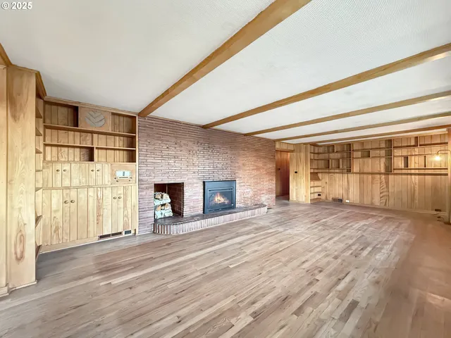 a view of a room with wooden floor and fireplace