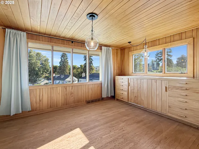 a view of a room with furniture large windows and wooden floor