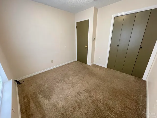 an empty room with a ceiling fan and window