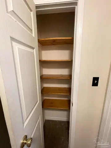 a view of walk in closet with clothes and door