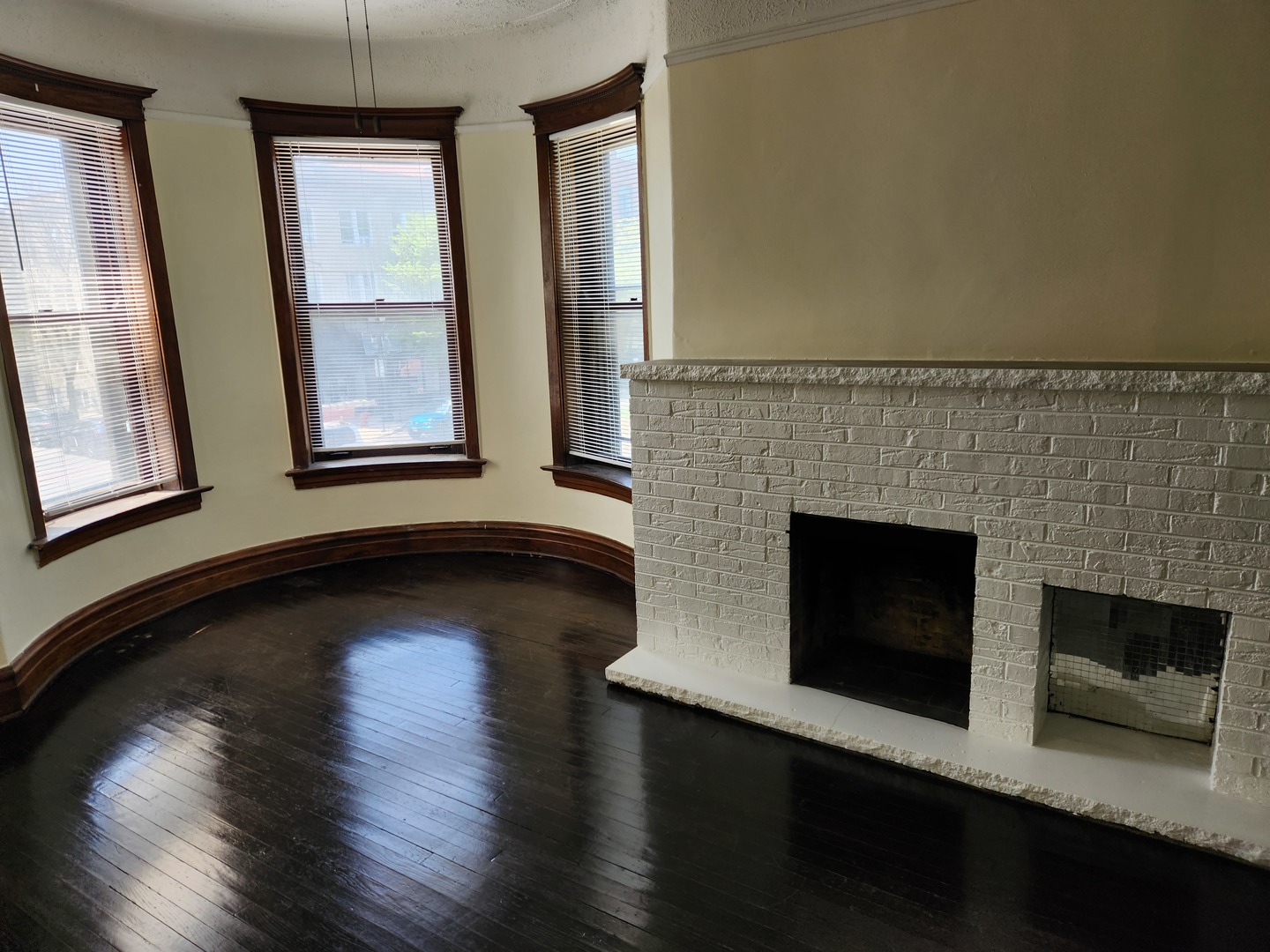 2224 West Irving Park Road, Unit 2 Chicago, IL 60618 - Photo 4 of 11 an empty room with wooden floor fireplace and windows