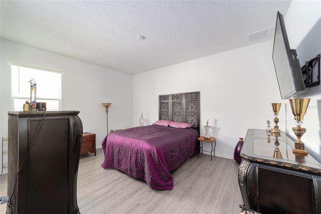 7233 Southwest 64th St Road Ocala, FL 34474 - Photo 28 of 48 a bedroom with a bed and a flat tv screen on the dresser