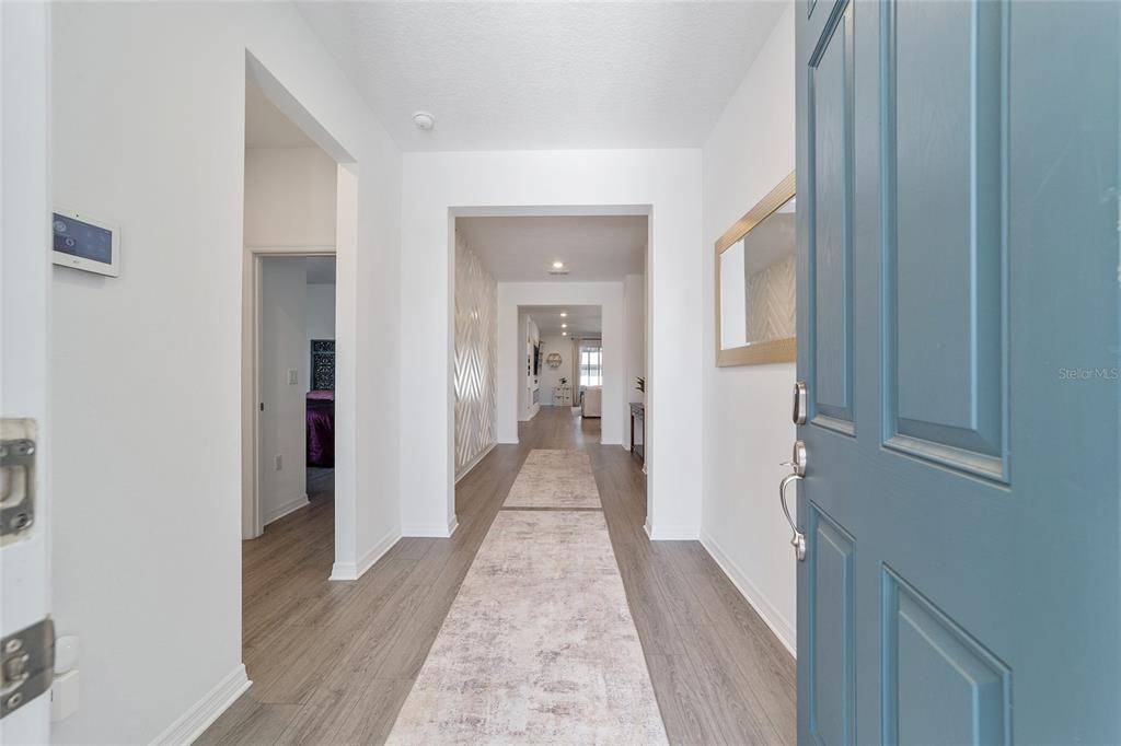 7233 Southwest 64th St Road Ocala, FL 34474 - Photo 4 of 48 a view of a hallway with wooden floor and a bathroom
