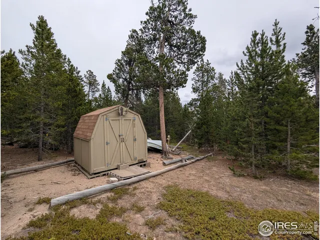 a view of a dry yard with wooden fence