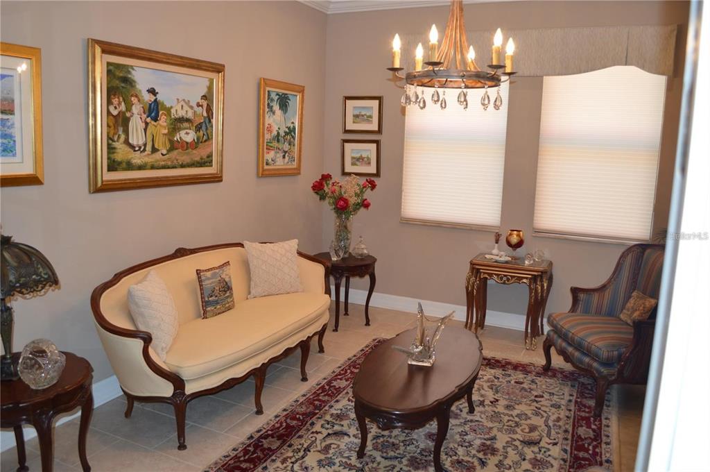 32026 Wenlock Loop Wesley Chapel, FL 33543 - Photo 12 of 52 a living room with furniture a chandelier and a dining table