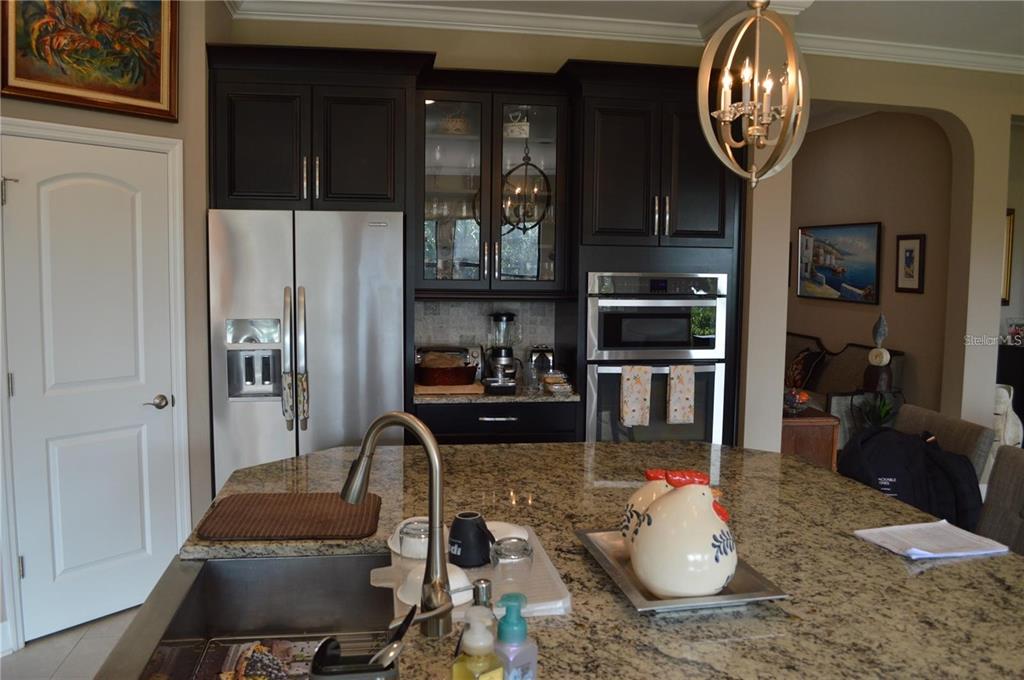 32026 Wenlock Loop Wesley Chapel, FL 33543 - Photo 22 of 52 a kitchen with sink refrigerator and cabinets
