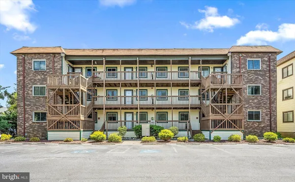 a front view of multi story residential apartment building with yard