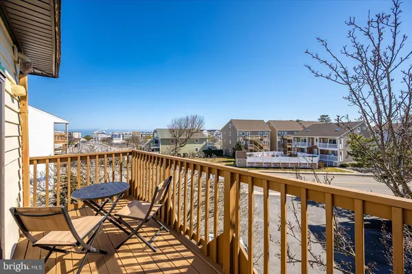 a view of a balcony with table and chairs and wooden fence