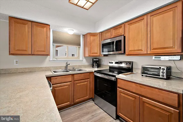 a kitchen with stainless steel appliances granite countertop a stove sink microwave and cabinets