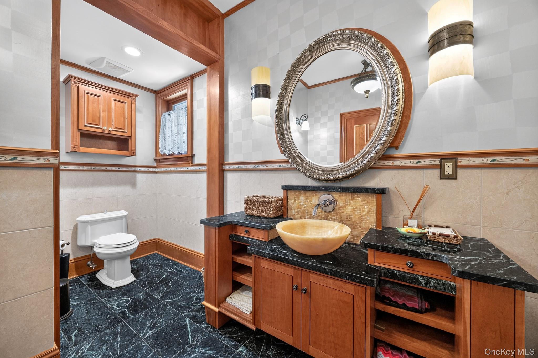 23 Inningwood Road Ossining, NY 10562 - Photo 29 of 50 Vanity featuring a vessel sink, dark countertop, and custom cabinetry with open shelving