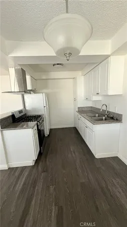 a kitchen with granite countertop a sink and a stove