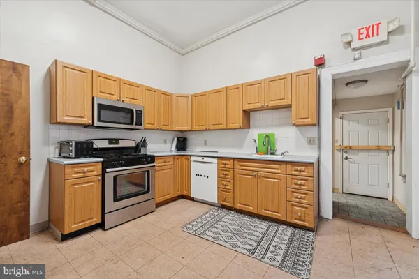 a kitchen with stainless steel appliances granite countertop a refrigerator and a stove top oven