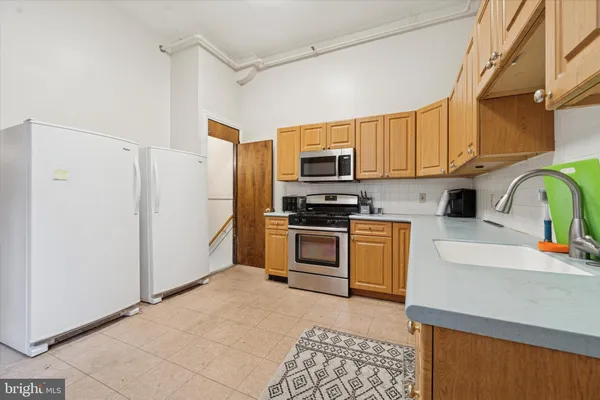 a kitchen with stainless steel appliances granite countertop a refrigerator a stove top oven a sink and dishwasher