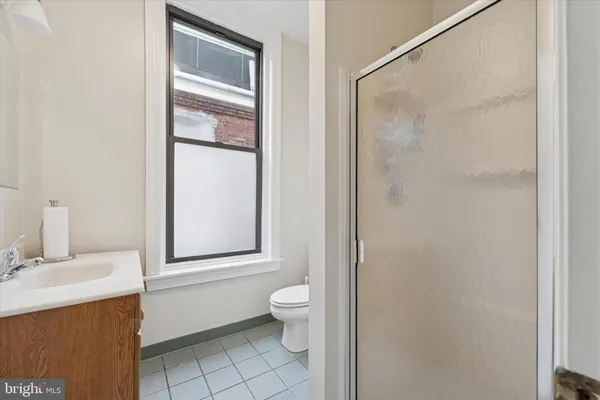 a bathroom with a granite countertop sink toilet and mirror