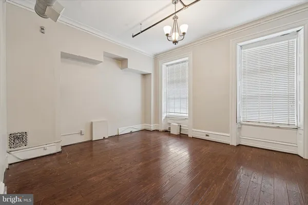 an empty room with wooden floor and window