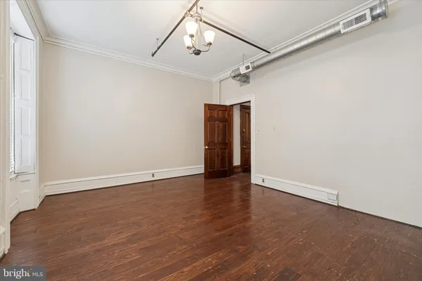 a view of an empty room with wooden floor