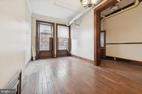 an empty room with wooden floor and a window