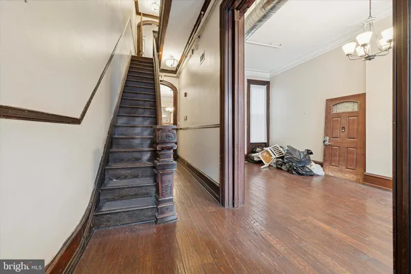 a view of a livingroom with wooden floor and stairs