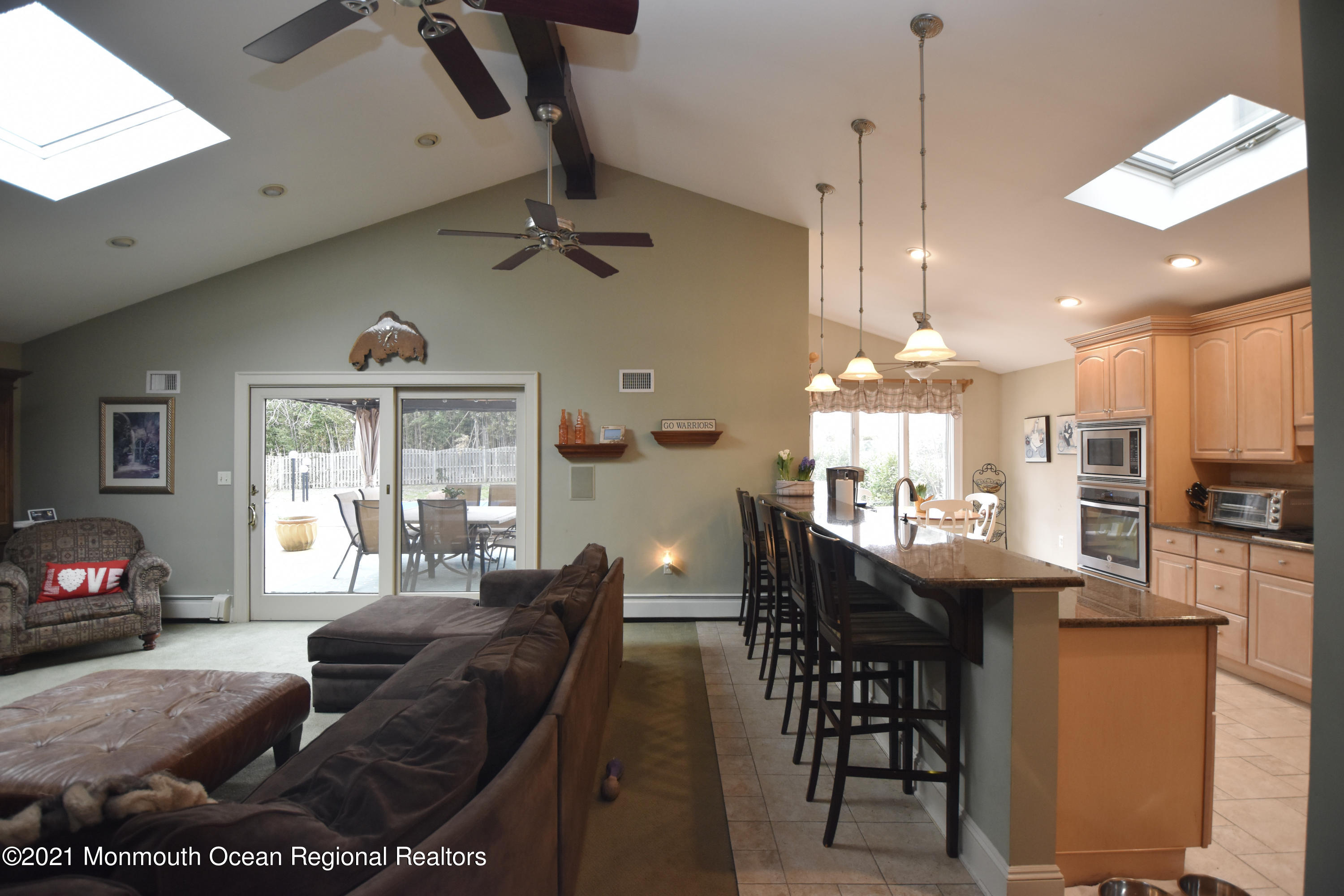 1007 Cedar Lane Brielle, NJ 08730 - Photo 11 of 46 a living room with kitchen island furniture and a chandelier