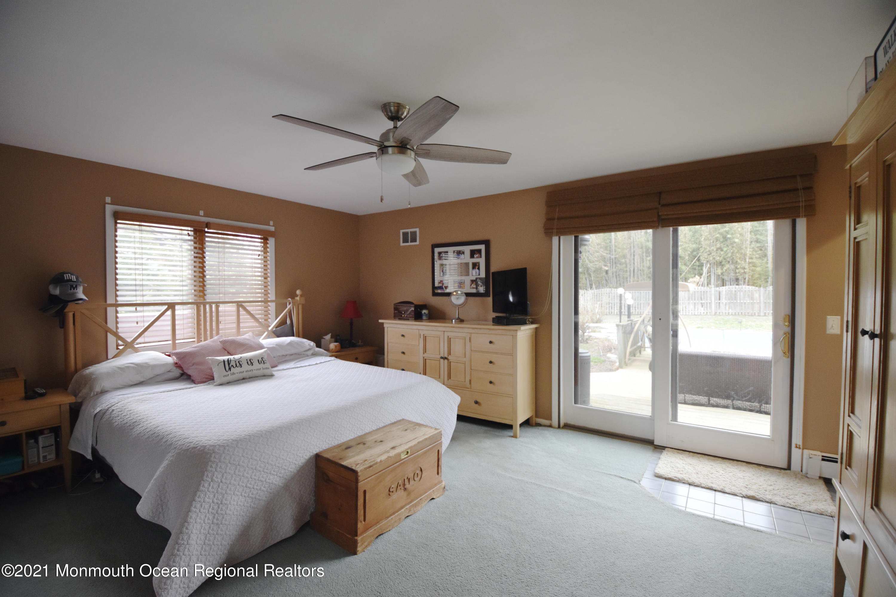 1007 Cedar Lane Brielle, NJ 08730 - Photo 21 of 46 a spacious bedroom with a large bed and a chandelier