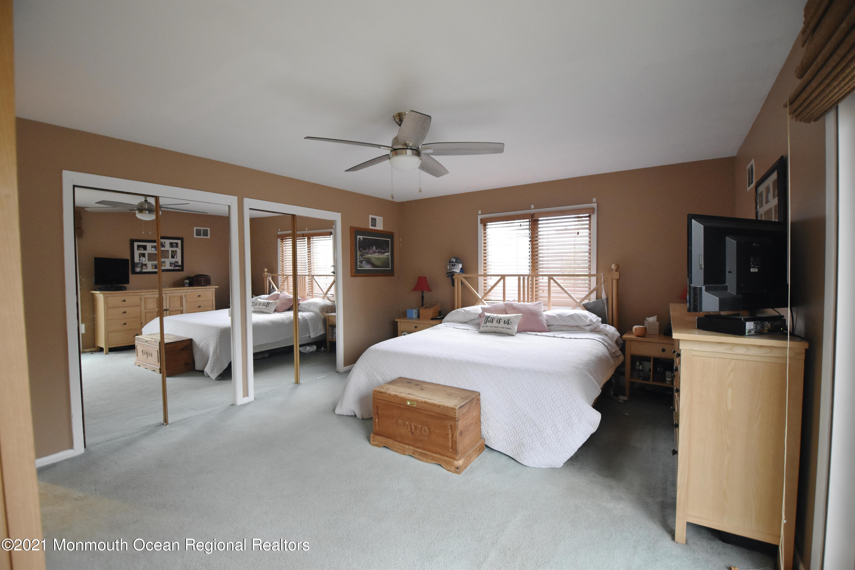 1007 Cedar Lane Brielle, NJ 08730 - Photo 22 of 46 a spacious bedroom with a bed and a chandelier