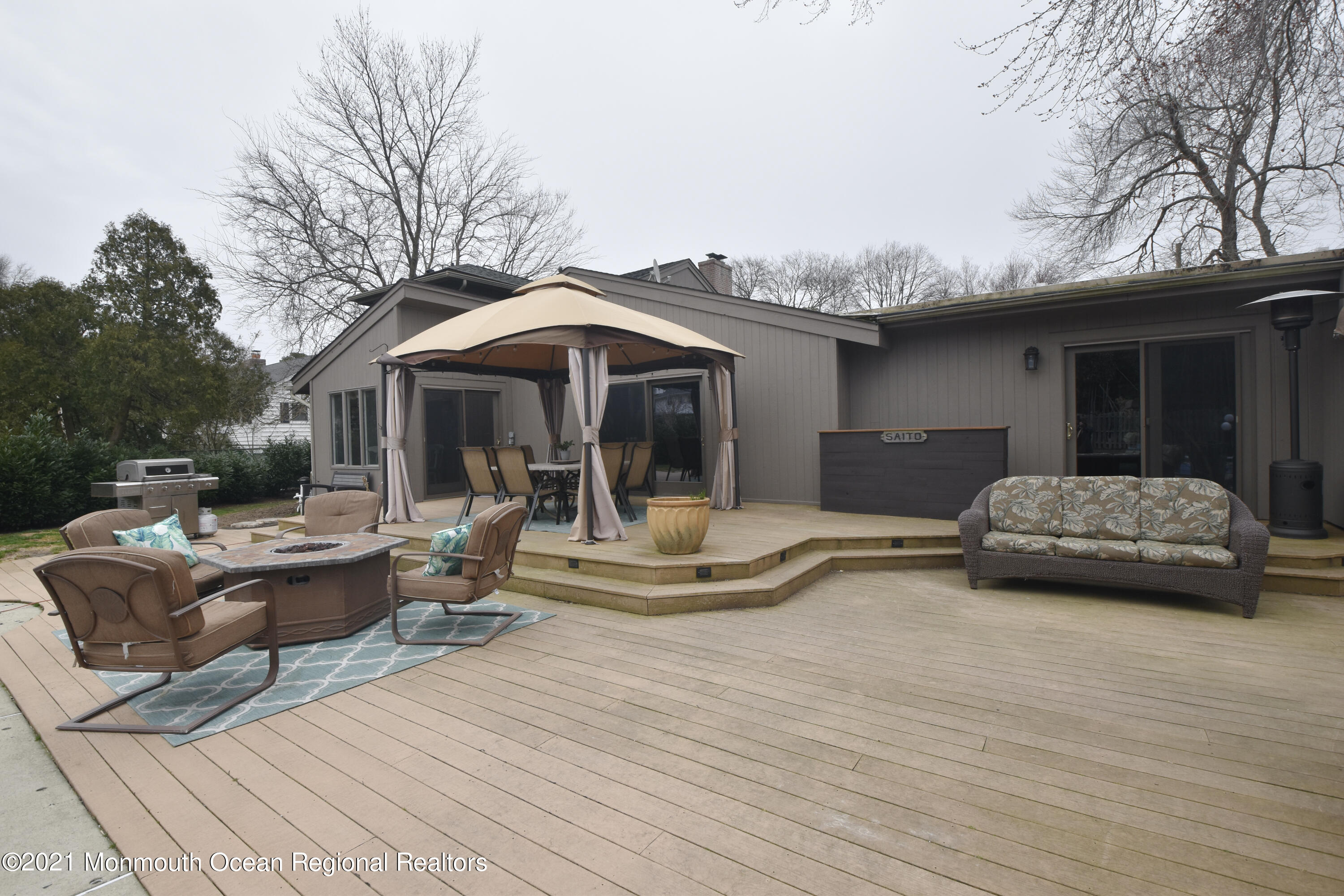 1007 Cedar Lane Brielle, NJ 08730 - Photo 40 of 46 a view of a patio with couches table and chairs under an umbrella